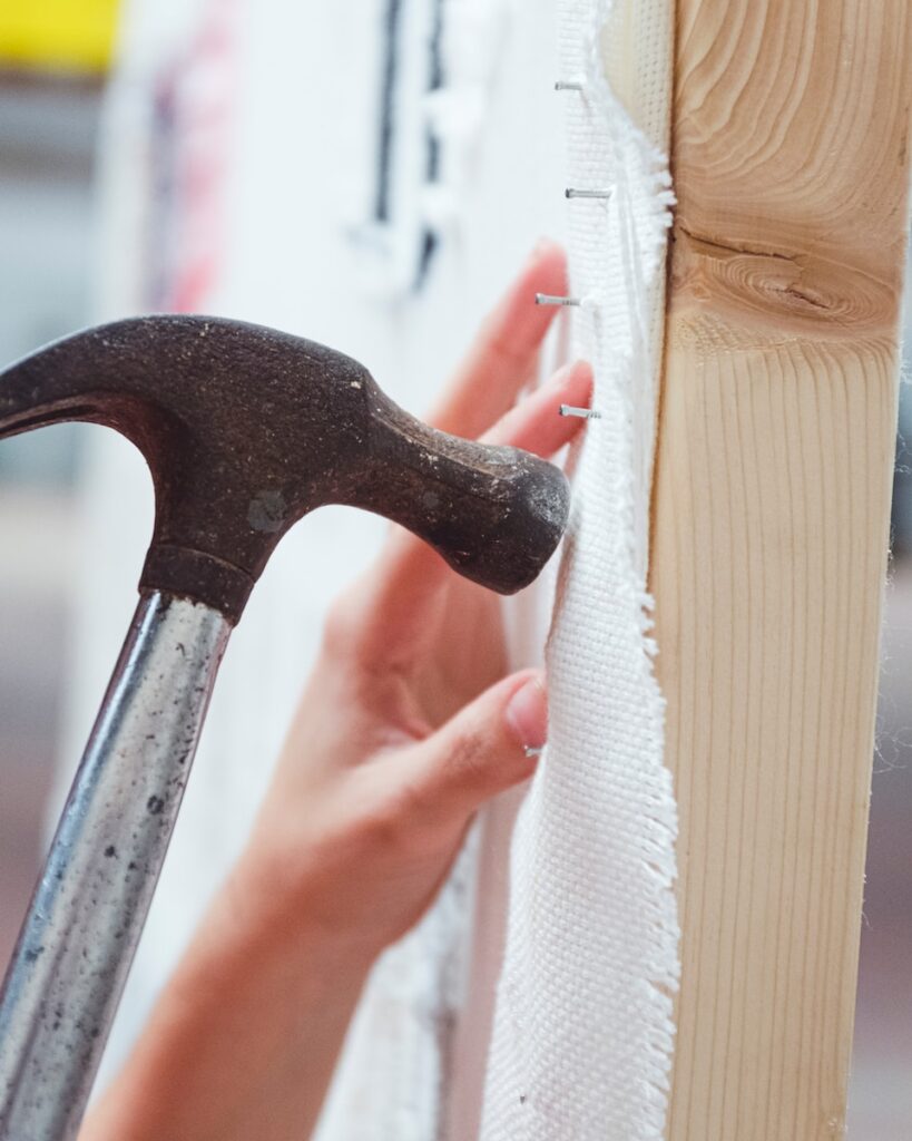 person holding black and silver claw hammer