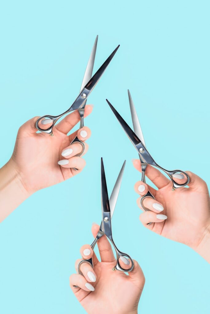 a pair of hands holding a pair of scissors